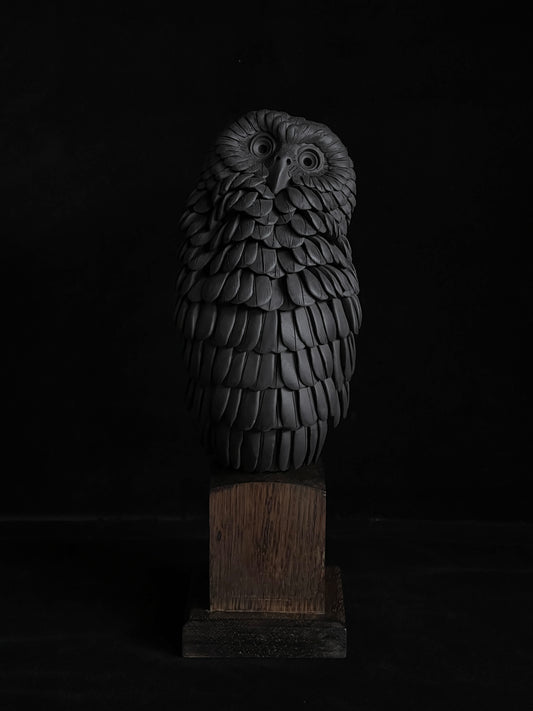 Nocturne XX by Tim Main, a black stoneware ruru (morepork) sculpture with its head tilted upwards, on an oak base.